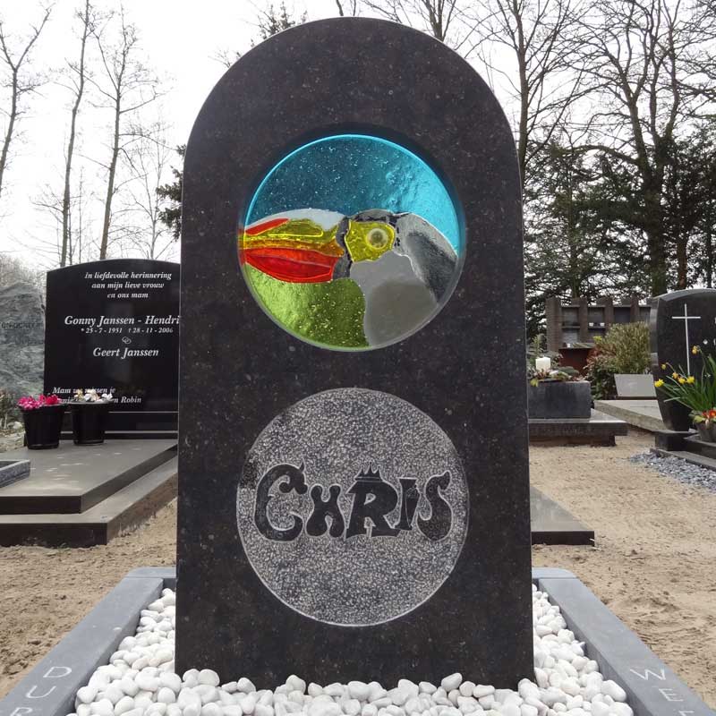 in het glas van dit grafmonument zien we een toekan